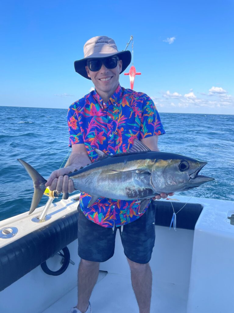 A brightly dressed angler holding a blackfin tuna.