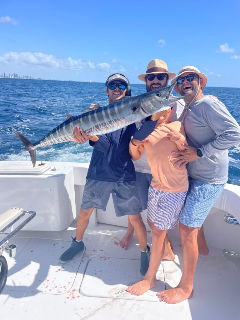 Group of happy anglers showing off their wahoo.